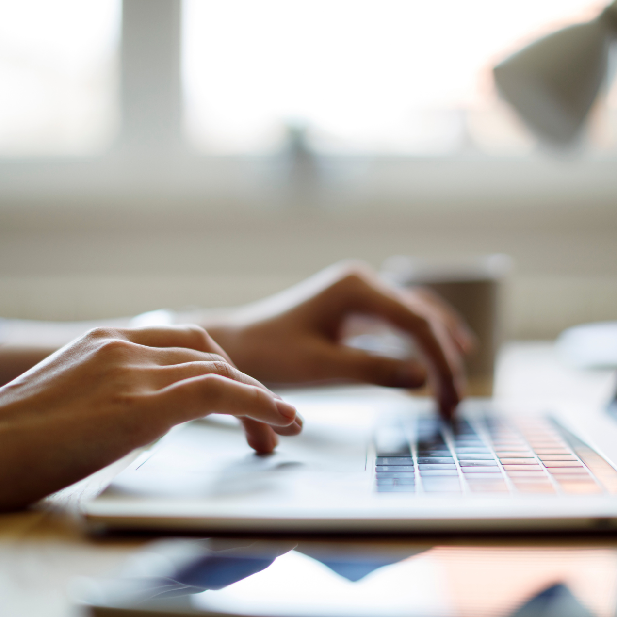 Hands typing on laptop